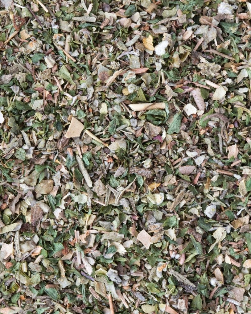 A close-up view of dried mixed herbs, showing a variety of chopped herbs.