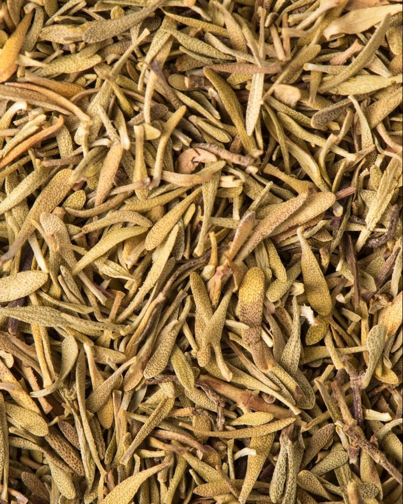 A close-up image of dried thyme, showing the dried leaves scattered together.